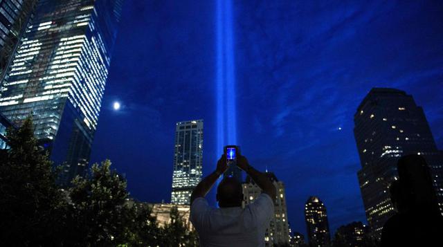 Un hombre fotografía las luces que simbolizan las dos torres del World Trade Center en Nueva York la noche antes del 15 aniversario del 11 de septiembre de 2001, día de los ataques terroristas contra Estados Unidos. (Foto: AFP)
