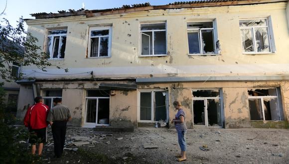 La gente se para fuera de un hospital destruido como resultado del bombardeo entre las fuerzas ucranianas y los separatistas prorrusos en la ciudad de Donetsk, en el este de Ucrania. (Foto:  ALEKSEY FILIPPOV / AFP)