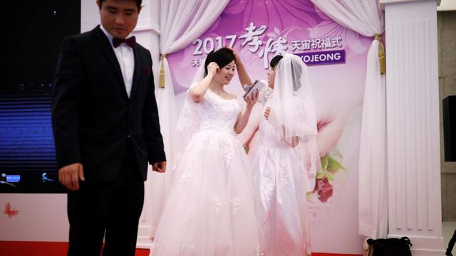FOTO 13 | Dos novias se preparan para para participar en la ceremonia de boda masiva.