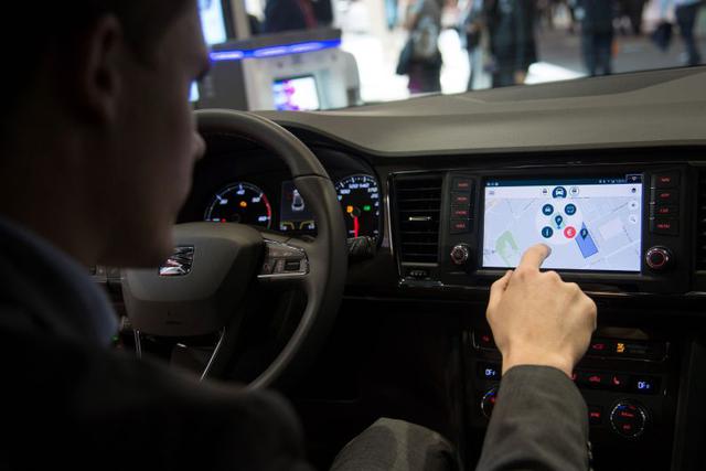 Un visitante prueba la app Travipay en un vehículo SEAT durante la feria MWC. (Foto: AFP)