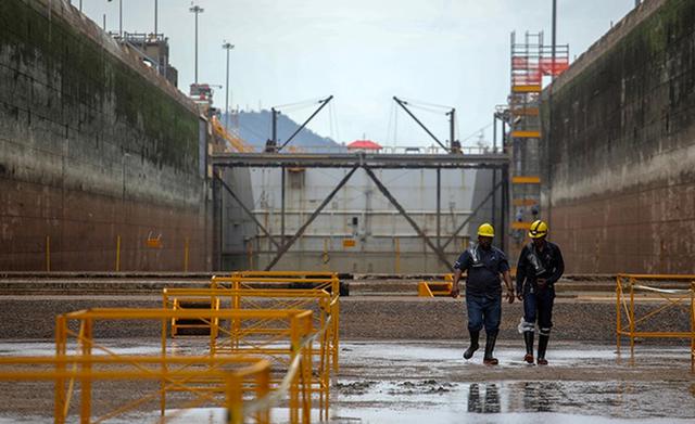 FOTO 1 | En turnos de 12 horas, 350 obreros por la mañana y 250 por la noche realizan operaciones de mantenimiento a las instalaciones del canal de Panamá, por donde pasa el 5% del comercio marítimo mundial. (Foto: AFP)
