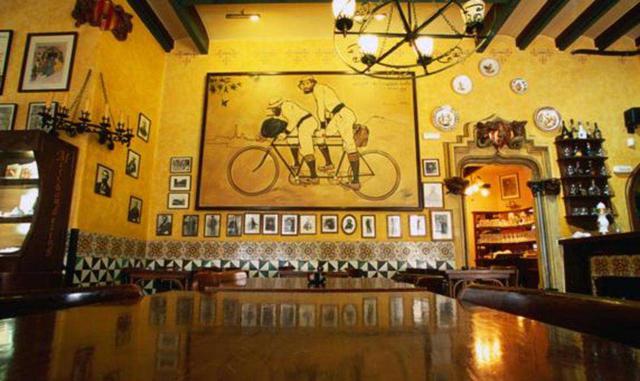 Els Quatre Gats (Barcelona, España). Situado en la calle Montsió, en el casco antiguo de Barcelona, Els Quatre Gats ocupa los bajos de un edificio modernista diseñado por el arquitecto Josep Puig i Cadafalch. El establecimiento, inaugurado a finales del s