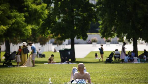 Un hombre toma el sol en un parque el sábado 18 de junio de 2022 en París. (AP Photo/Thomas Padilla)