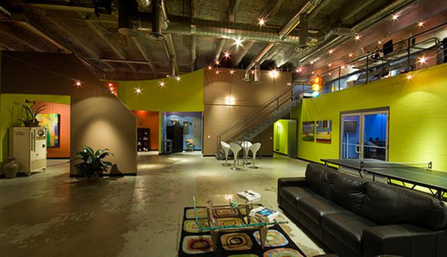 FOTO 16 |  16. Traction Marketing Group – Oklahoma.

Esta empresa comenzó teniendo un simple almacén o depósito, pero rápidamente lo fue transformando con mucha creatividad. Las paredes son de distintos colores muy llamativos, con una interesante mezcla de azules, verdes, marrones y grises dispersos a lo largo de un espacio bastante amplio.

Eliminaron la áspera iluminación fluorescente y apostaron por las lámparas individuales y las hileras, como la que pasa sobre la mesa de ping-pong. El suave piso de concreto sirve de soporte para múltiples áreas donde los empleados pueden tomarse un descanso, y la enorme puerta de vidrio tipo garaje permite la entrada de mucha luz natural, haciendo más cómodo el ambiente de trabajo. (Foto: viralismo)