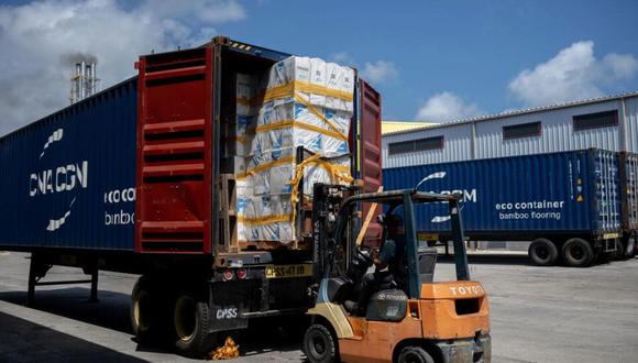 Trabajadores cargan mercancía en un camión en la Zona Franca del puerto en Willemstad. Foto: AFP