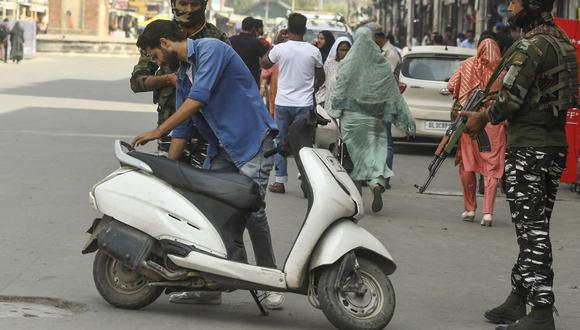 Soldados paramilitares indios revisan el scooter de un hombre durante una búsqueda aleatoria en una calle de Srinagar el 3 de octubre de 2022, antes de la visita del ministro del Interior de la India, Amit Shah, a Jammu y Cachemira. (Foto de TAUSEEF MUSTAFA / AFP)