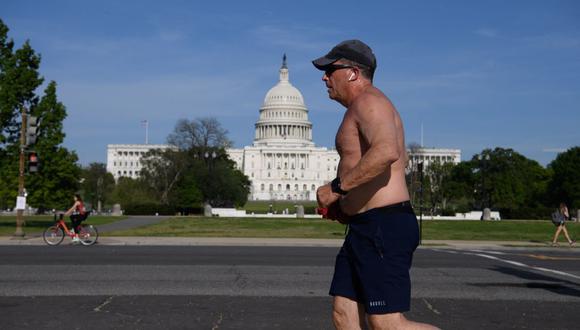 Un hombre que no usa mascarilla pasa corriendo por el Capitolio de Estados Unidos en Washington, DC. (Imagen referencial de Nicholas Kamm / AFP).