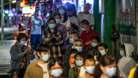 Decenas de personas guardan cola para hacerse una prueba de detección del coronavirus el 15 de mayo de 2022 en la ciudad china de Guangzhou . AFP