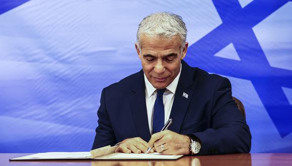 El primer ministro israelí, Yair Lapid, firma el acuerdo negociado por Estados Unidos que establece una frontera marítima entre Israel y el Líbano. (Foto: RONEN ZVULUN / POOL / AFP)