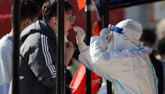 Un trabajador médico toma una muestra de un residente para realizar la prueba del coronavirus en Xi'an, en la provincia de Shaanxi, en el norte de China, el 21 de diciembre de 2021. (Foto:  AFP)