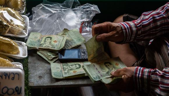 A vendor counts Thai baht notes at a floating market in Damnoen Saduak, Thailand, on Monday, April 3, 2023. Thailand is scheduled to release consumer price index (CPI) on April 5. Photographer: Eduardo Leal/Bloomberg