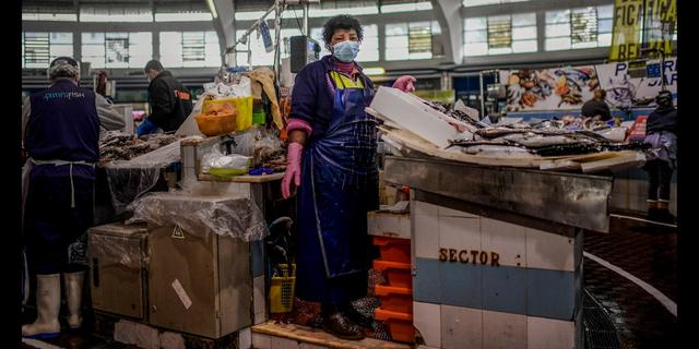 FOTO 8 | Portugal. Una mujer dedicada a la pescadería posa en el mercado de Benfica en Lisboa. Para Emilia Lomba es un riesgo ir a trabajar porque conoce a muchas personas todos los días, pero necesita hacerlo para pagar sus facturas. Cree que tiene suerte de poder estar afuera comunicándose con sus clientes y proporcionándoles pescado fresco. Foto Afp / Patricia de Melo