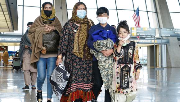 Los refugiados afganos caminan hacia un autobús que los lleva a un centro de procesamiento al llegar al Aeropuerto Internacional de Dulles en Dulles, Virginia, Estados Unidos, el 26 de agosto de 2021. (REUTERS / Kevin Lamarque).