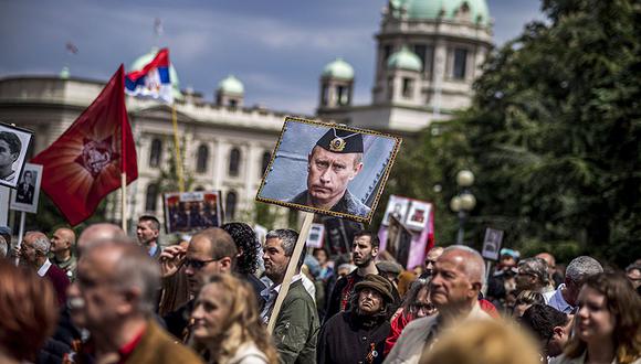 Un hombre lleva un retrato del presidente ruso Vladimir Putin durante la marcha del Regimiento Inmortal en el centro de Belgrado, Serbia, celebrando el 72 aniversario de la victoria aliada sobre la Alemania nazi en la Segunda Guerra Mundial. (Foto: AF).