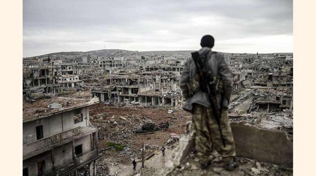 Un soldado sirio se asoma a las ruinas de Kobane, al norte de Siria, otra de las ciudades castigadas por el conflicto.(foto:Diario ABC, S.L.)