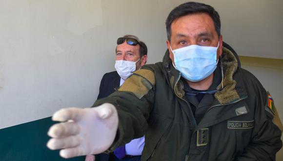Policías bolivianos custodian a Marcelo Navajas, quien fue arrestado en un caso de supuesta corrupción, en el marco de la investigación de una compra con sobreprecio en España de respiradores para hospitales. EFE/STRINGER