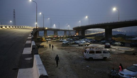 Gente camina bajo un puente mientras anochece en Lagos el 28 de febrero. Foto: George Osodi/Bloomberg