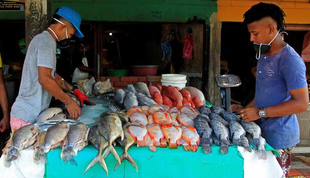 Dos jóvenes venden pescado en el mercado de Bazurto, principal centro de acopio de Cartagena de Indias (Colombia). (EFE/ Ricardo Maldonado Rozo).