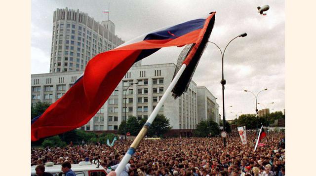 Una bandera rusa ondea entre la multitud de ciudadanos que participan en los funerales de las víctimas del golpe delante de la Casa Blanca de Moscú, el 24 de agosto de 1991.(foto:Alexander Nemenov).