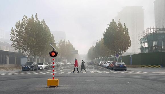 Dos peatones cruzan una carretera casi desierta en Beijing, China, el viernes 25 de noviembre de 2022. Foto: Bloomberg