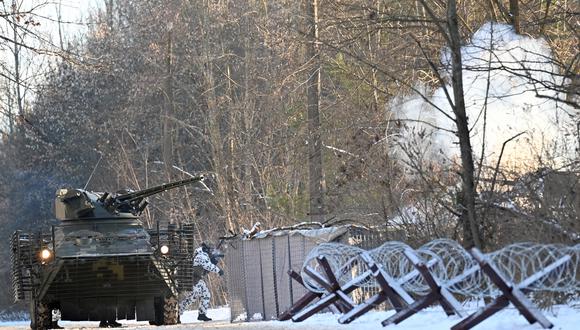 Los militares, junto a un vehículo blindado, participan en ejercicios tácticos y especiales conjuntos del Ministerio del Interior de Ucrania, la Guardia Nacional de Ucrania y el Ministerio de Emergencias en una ciudad fantasma de Pripyat, cerca de la planta de energía nuclear de Chernobil. (Foto: Sergei Supinsky / AFP)