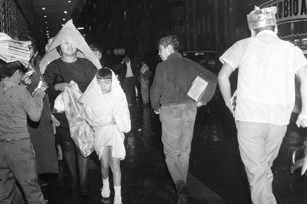 15 de enero de 1970, lluvias torrenciales afectan a la ciudad de Lima. En la imagen un grupo de transeúntes se protegen de la intensa lluvia. (Foto GEC Archivo Histórico) 