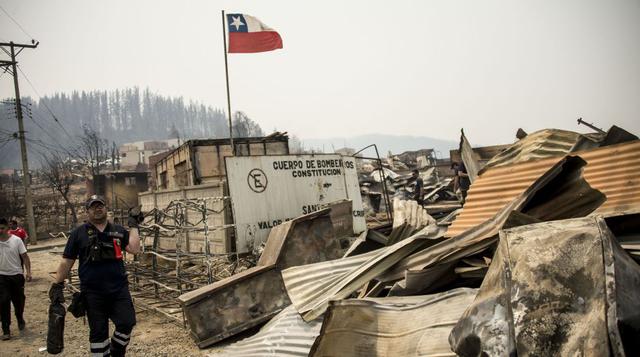 1. Una bandera chilena ondea en la estación de bomberos quemada de Santa Olga, 350 kilómetros al sur de Santiago. (Foto: AFP)