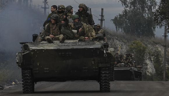 Soldados ucranianos sentados en vehículos de combate de infantería mientras conducen cerca de Izyum, en el este de Ucrania, el 16 de septiembre de 2022, en medio de la invasión rusa de Ucrania. (Foto por Juan BARRETO / AFP)