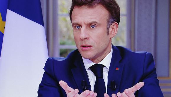 El presidente francés, Emmanuel Macron, se ve en la pantalla mientras habla durante una entrevista televisiva desde el Palacio del Elíseo, en París, el 22 de marzo de 2023. (Foto de Ludovic MARIN / AFP)