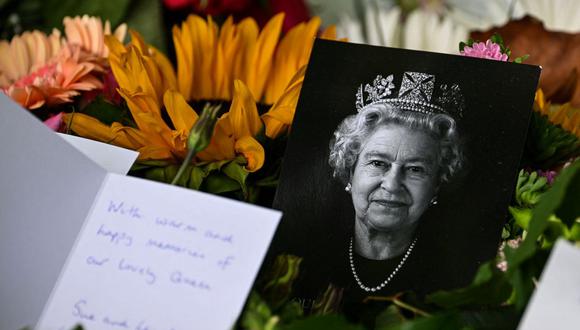 Un retrato de la difunta reina Isabel II se muestra entre las flores y los tributos dejados en Green Park en Londres el 18 de septiembre de 2022, luego de su muerte el 8 de septiembre. (Foto de SEBASTIEN BOZON / AFP)