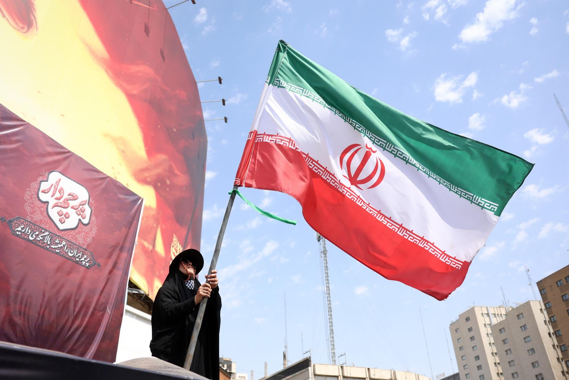Una mujer ondea la bandera nacional de Irán en Teherán el 17 de agosto de 2026 (EFE).