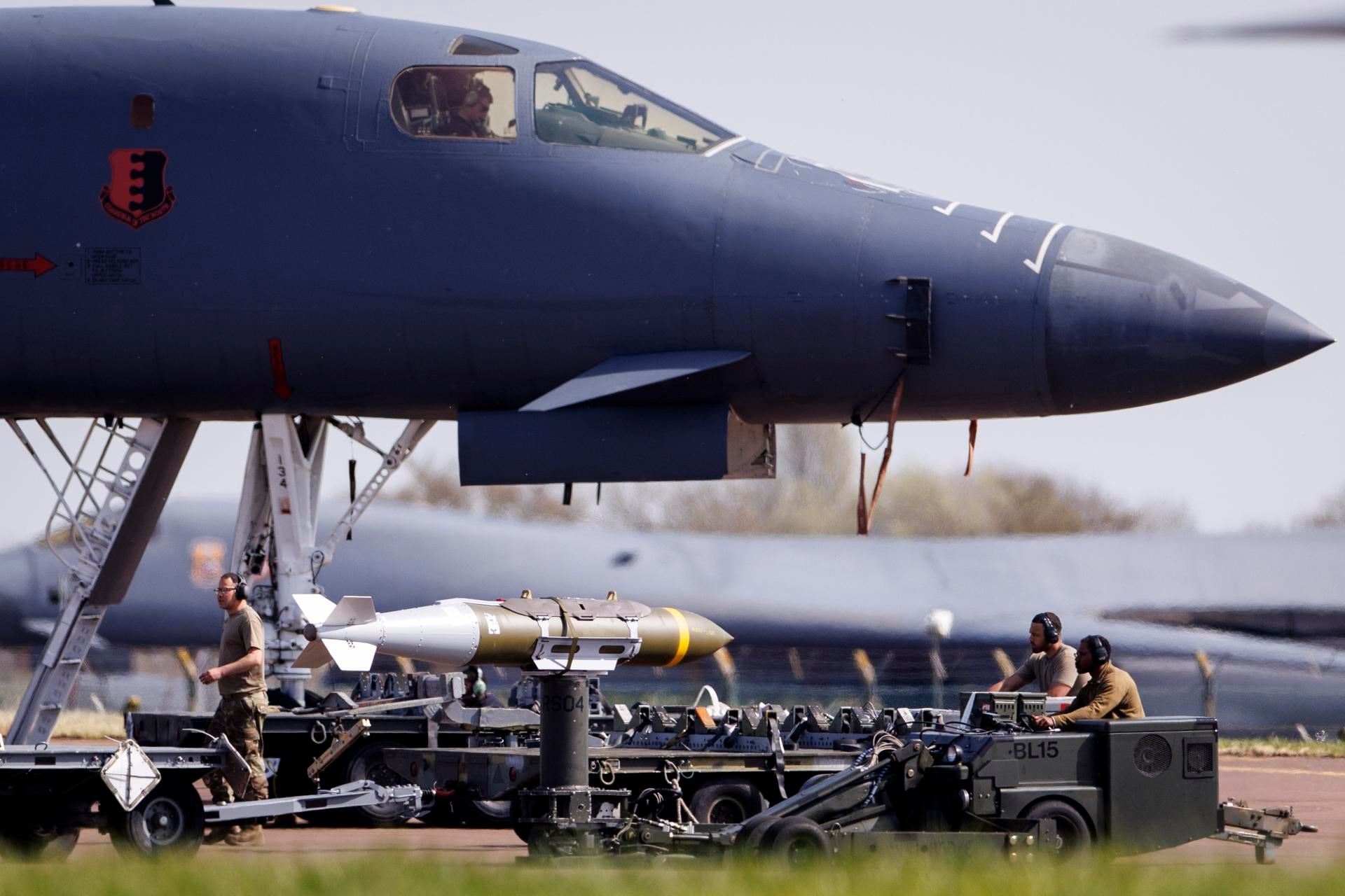 Personal militar de la Fuerza Aérea de Estados Unidos junto a munición guiada de precisión JDAM y un bombardero pesado Rockwell B-1 Lancer en la pista de la base aérea RAF Fairford en Gloucestershire, Gran Bretaña. (EFE/EPA/TOLGA AKMEN).