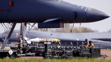 Personal militar de la Fuerza Aérea de Estados Unidos junto a munición guiada de precisión JDAM y un bombardero pesado Rockwell B-1 Lancer en la pista de la base aérea RAF Fairford en Gloucestershire, Gran Bretaña. (EFE/EPA/TOLGA AKMEN).
