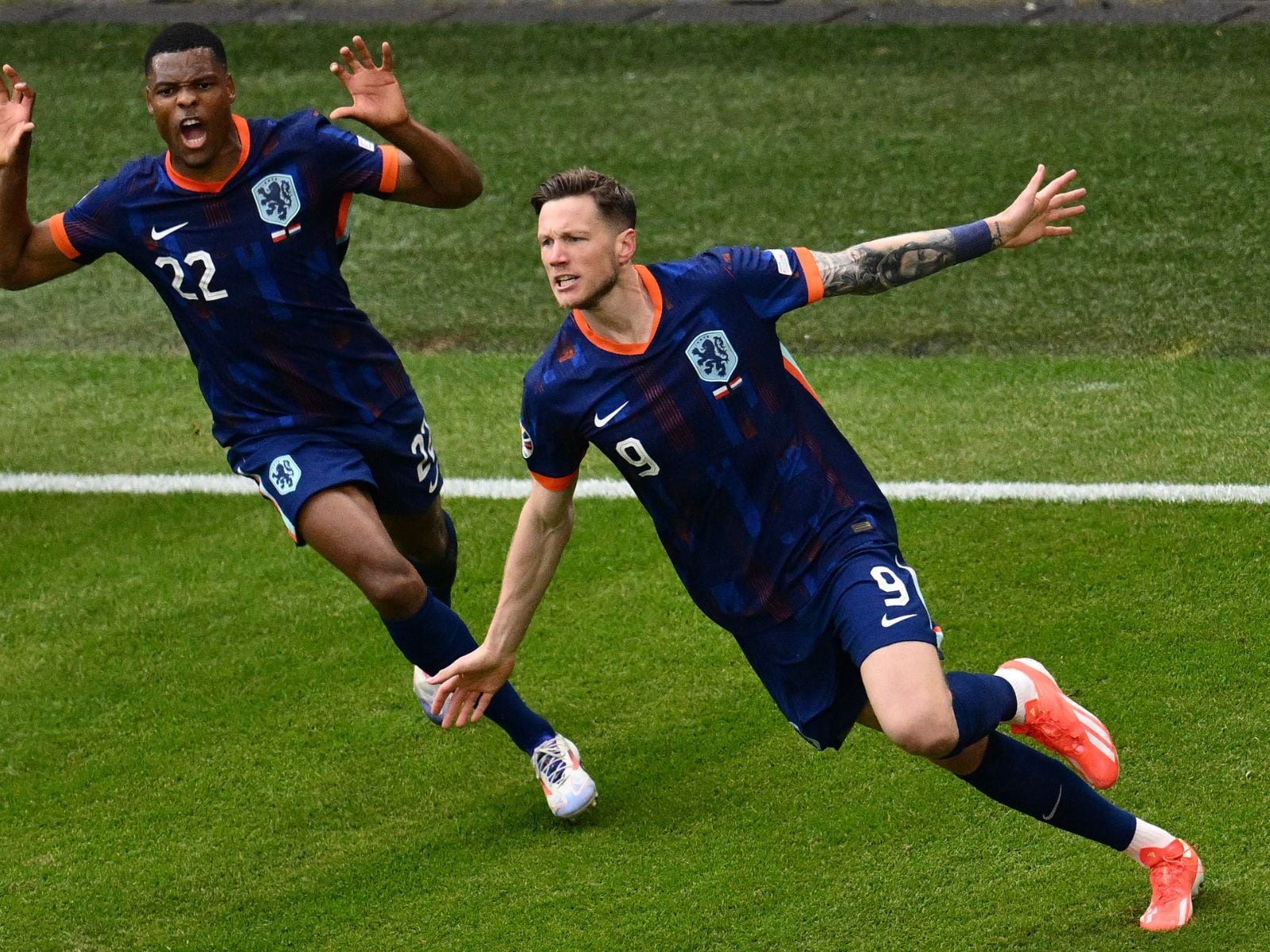 El delantero de Holanda #09 Wout Weghorst (d) celebra tras marcar el segundo gol de su equipo durante el partido de fútbol del Grupo D de la UEFA Euro 2024 entre Polonia y Holanda en el Volksparkstadion de Hamburgo el 16 de junio de 2024. | Crédito: Christophe Simon / AFP