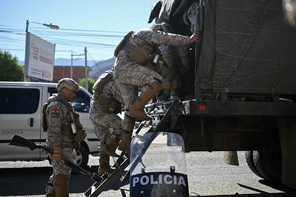 Fuerzas de seguridad suben a la parte trasera de un camión tras la reapertura de una carretera después de las protestas que exigían la renuncia del presidente de Bolivia, Rodrigo Paz, en Carreras, departamento de La Paz, Bolivia, el 5 de junio de 2026. (Foto de Marvin RECINOS / AFP)