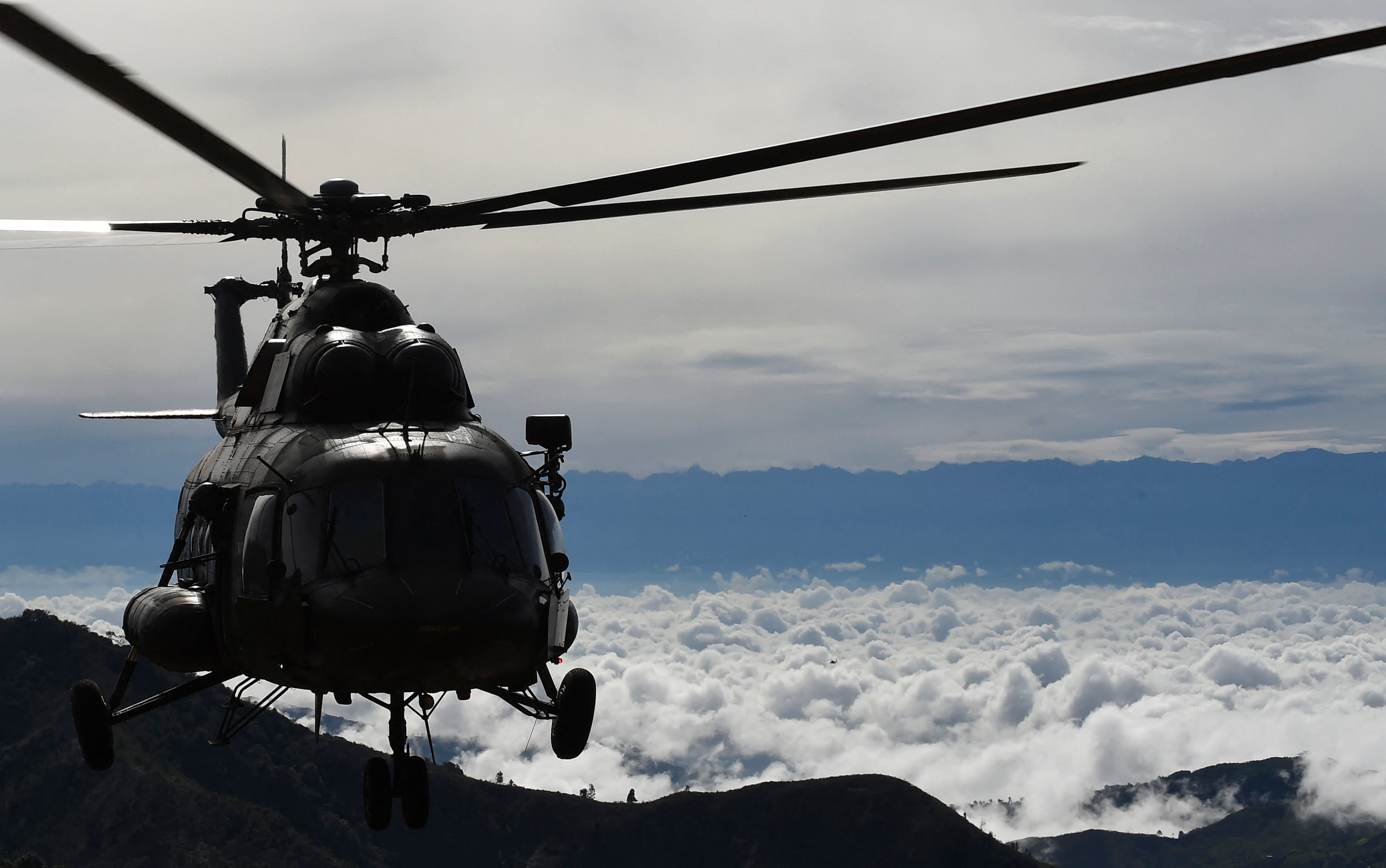Un helicóptero del ejército de Colombia sobrevuela una zona de desmovilización de las FARC en el departamento del Cauca, Colombia, el 13 de junio de 2017. (Foto de RAUL ARBOLEDA / AFP / Archivo).