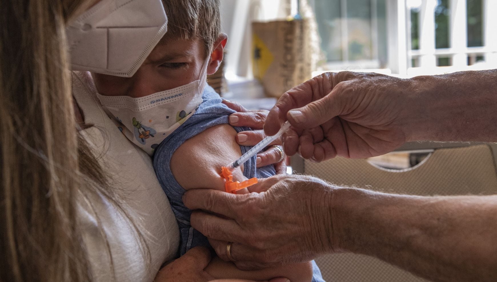 Una madre sostiene a su hijo de cuatro años mientras recibe la vacuna infantil (Foto: Joseph Prezioso / AFP)