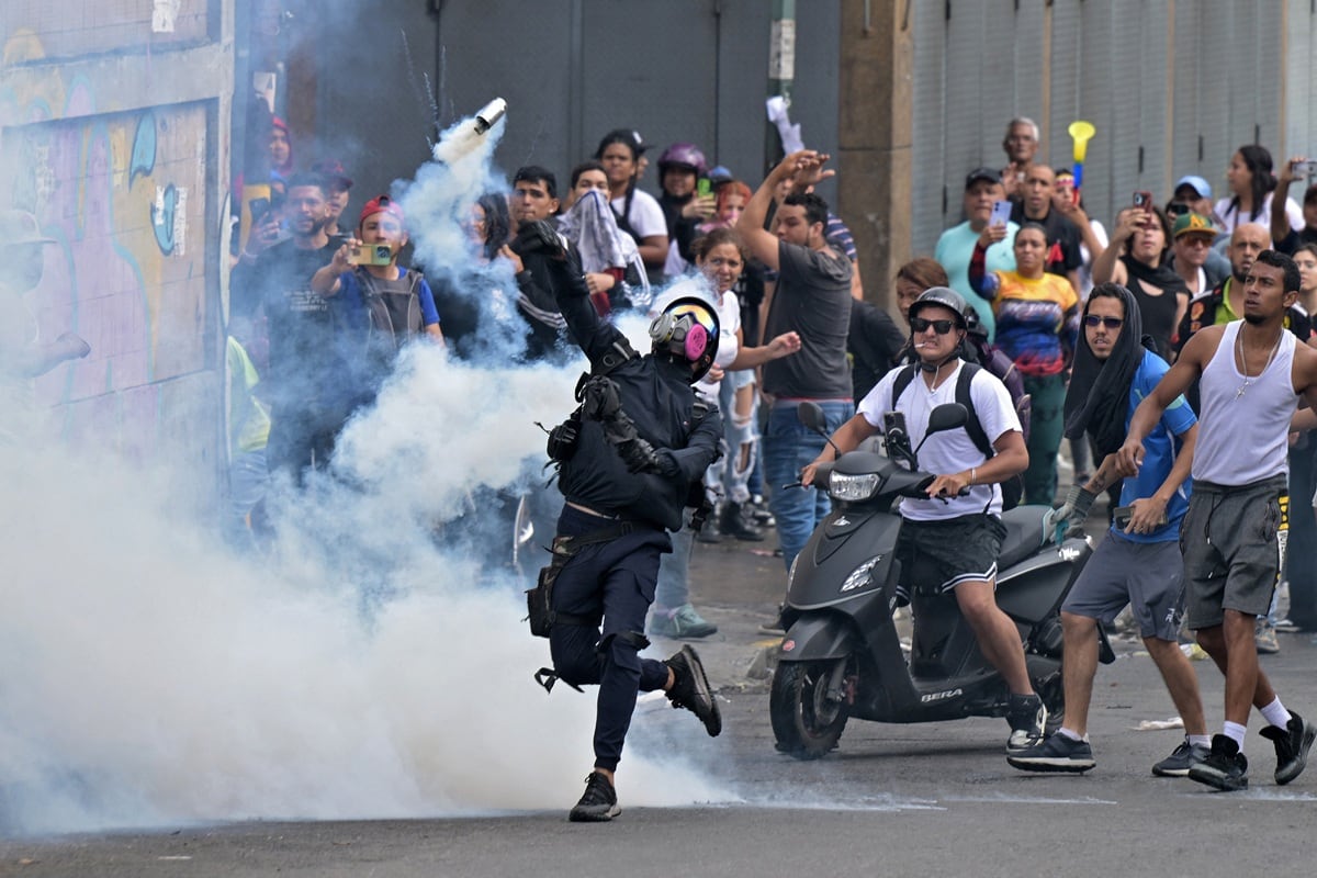 Opositores al gobierno de Nicolás Maduro se enfrentan con la policía antidisturbios durante una protesta en el barrio de Catia, en Caracas el 29 de julio de 2024, un día después de las elecciones presidenciales venezolanas. (Yuri CORTEZ / AFP)