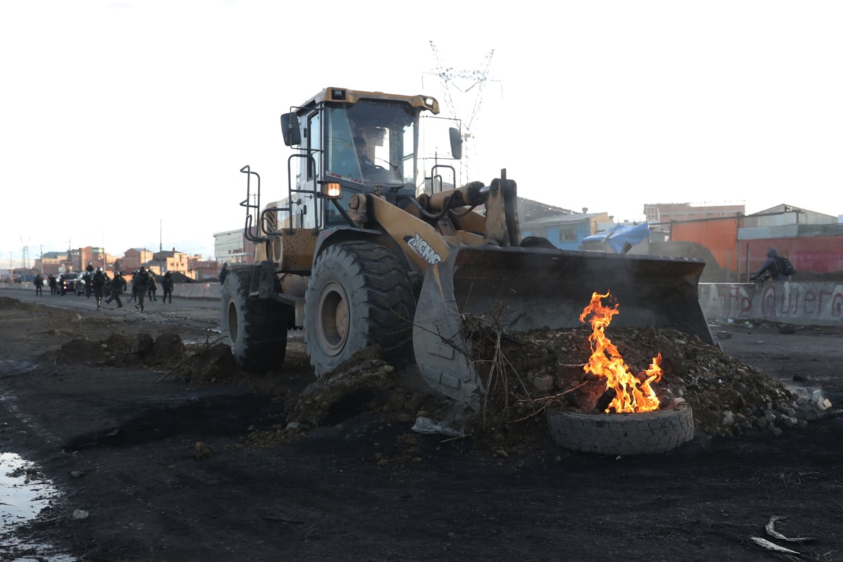 Tractores limpian escombros en la vía de La Paz con Oruro, en Ventilla, Bolivia. (Luis Gandarillas / EFE)