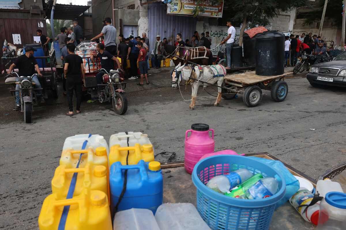 Palestinos hacen cola para recargar agua en el campo de refugiados de Rafah, en el sur de la Franja de Gaza, el 14 de octubre de 2023. (Foto de MOHAMMED ABED / AFP)