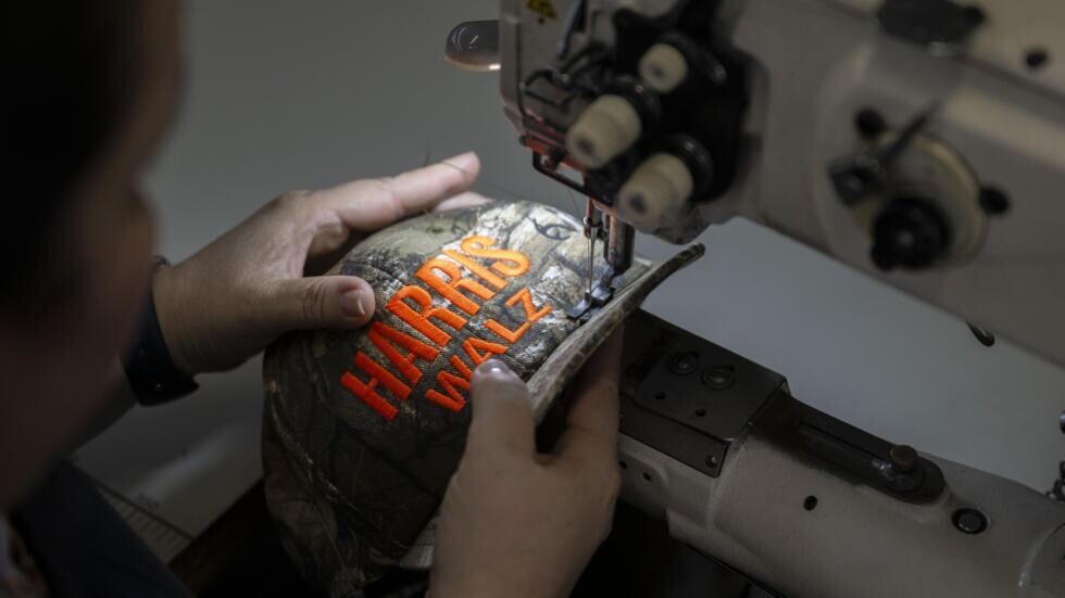 Una operaria cose una gorra de la campaña presidencial de la vicepresidenta, la demócrata Kamala Harris y su compañero de fórmula Tim Walz, actual gobernador de Minnesota, para las elecciones del 5 de noviembre en Estados Unidos, el 22 de agosto de 2024, en Newark, Nueva Jersey © ANGELA WEISS / AFP