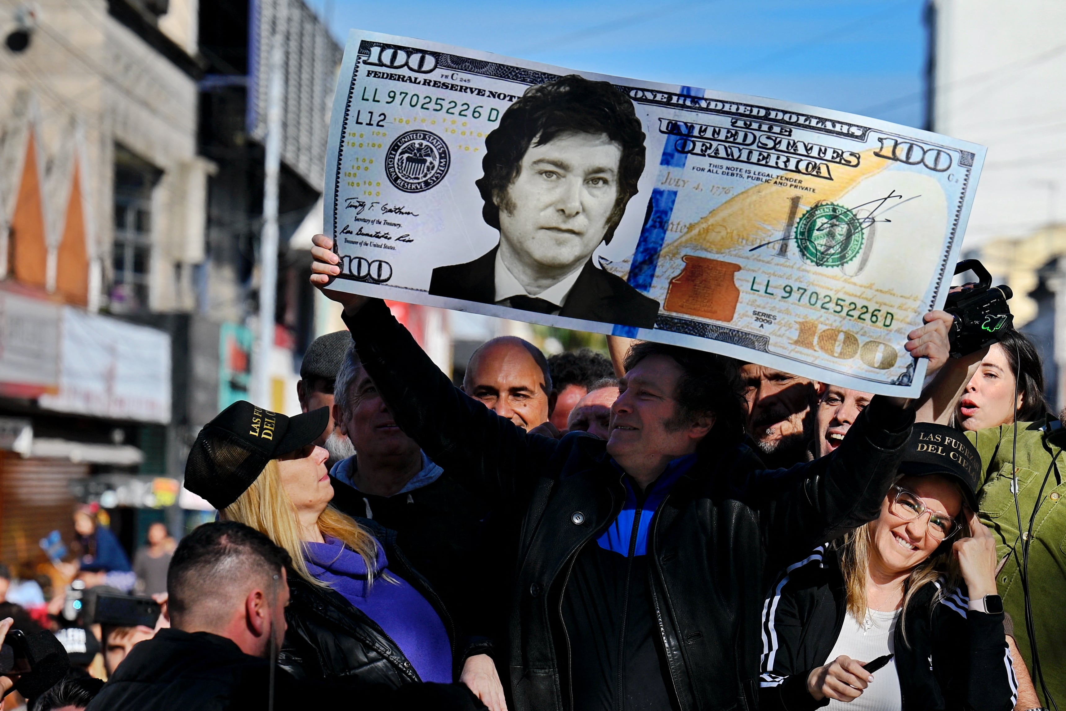 Javier Milei sostiene un billete gigante de 100 dólares con su cara pintada durante un mitin de campaña en San Martín, provincia de Buenos Aires, Argentina, el 25 de septiembre de 2023. (Foto de Luis ROBAYO/AFP).