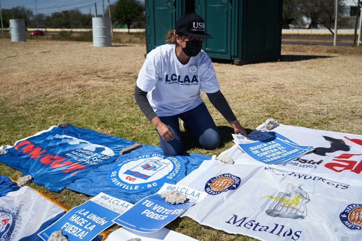 Un miembro del grupo de defensa del Consejo Laboral para el Avance de América Latina coloca carteles afuera del Complejo Silao de General Motors Co. (GM) durante una votación sindical en Silao, estado de Guanajuato, México, el miércoles 2 de febrero de 2022.