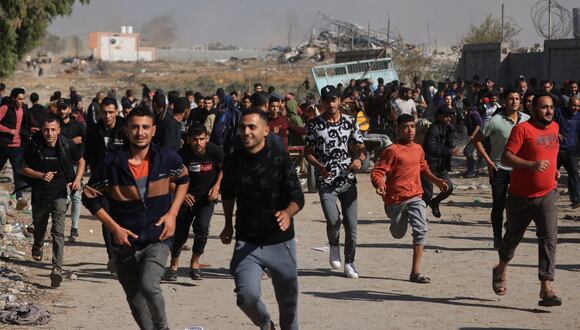 Los palestinos que abandonan el norte corren por la carretera Salaheddine en el distrito de Zeitoun en las afueras del sur de la ciudad de Gaza el 24 de noviembre de 2023, luego de un alto el fuego de cuatro días que comenzó temprano en la mañana. (Foto de MAHMUD HAMS / AFP)