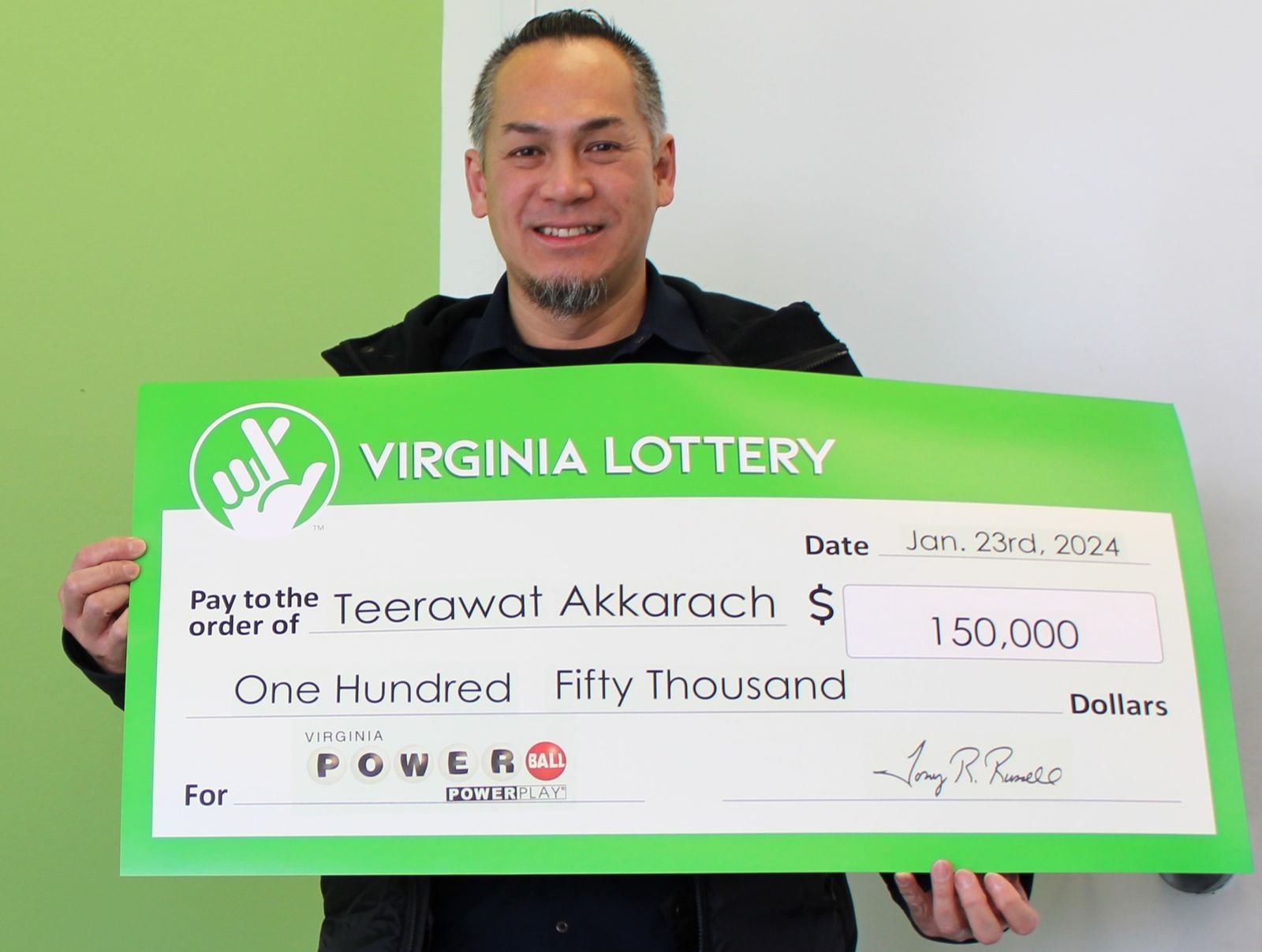 Teerawat Akkarach, de Maryland, posa feliz con su cheque de 150 mil dólares de Powerball. Aún no puede creer que su suerte haya cambiado (Foto: Lotería de Virginia)