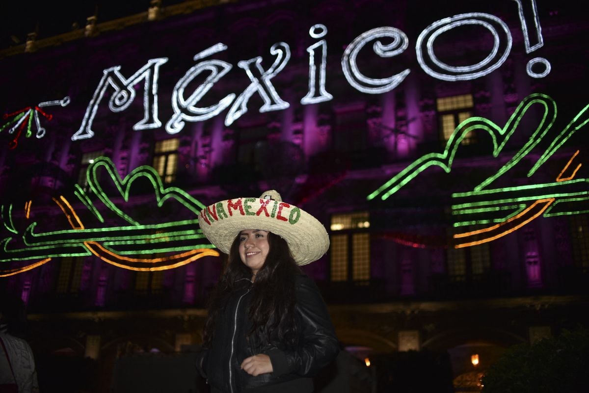 Una mujer posa frente al iluminado edificio del Municipio de México en vísperas de la celebración del Día de la Independencia de México en la Plaza del Zócalo de la Ciudad de México el 14 de septiembre de 2017 (Foto: Yuri Cortez / AFP )