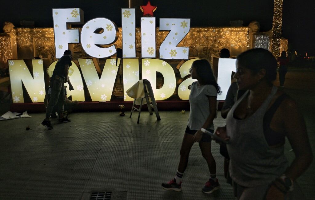 Mujeres jóvenes pasan junto a una decoración navideña en el complejo militar de Fuerte Tiuna en Caracas el 1 de octubre de 2024. El mes pasado, el presidente Nicolás Maduro hizo gran fanfarria al anunciar que la temporada navideña se adelantaría al 1 de octubre, aunque el espíritu público no refleja el brillo en un país sacudido por conflictos económicos y políticos desde su ampliamente cuestionada reelección para un tercer mandato de seis años en una votación del 28 de julio. (Foto de Juan BARRETO / AFP)