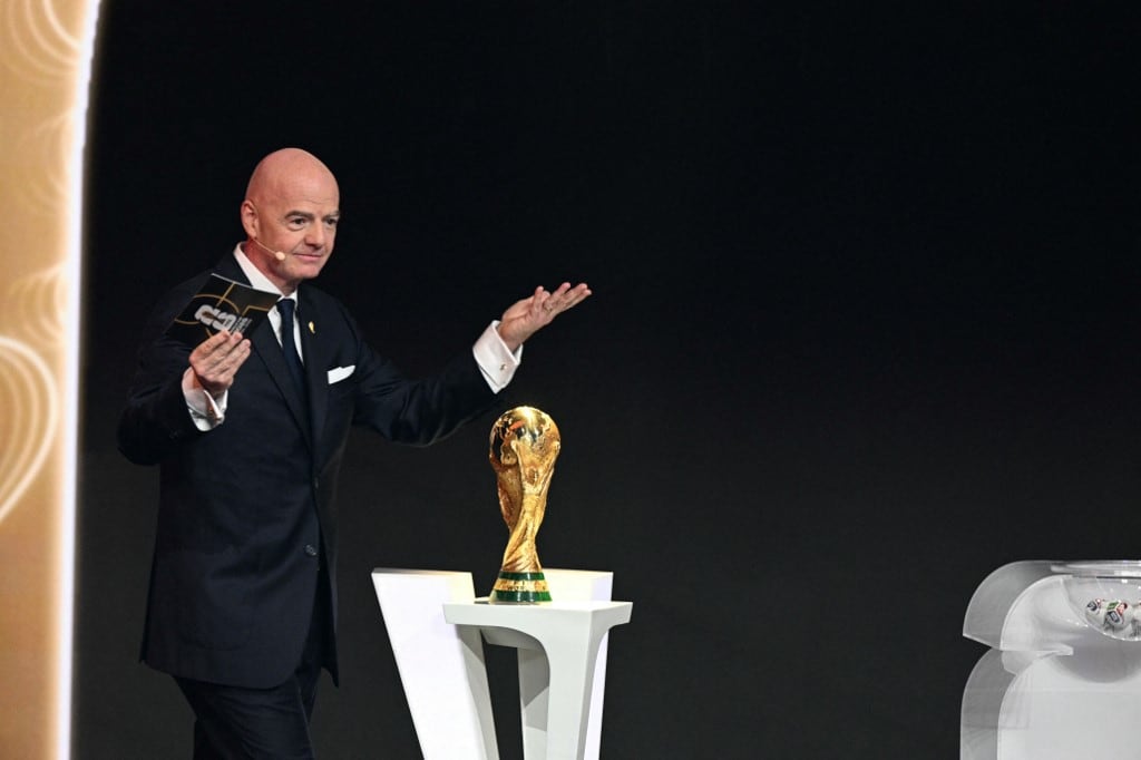 Italian Fifa President Gianni Infantino speaks next of the World Cup Trophy during the draw for the 2026 FIFA Football World Cup taking place in the US, Canada and Mexico, at the Kennedy Center, in Washington, DC, on December 5, 2025. (Photo by Jim WATSON / AFP)