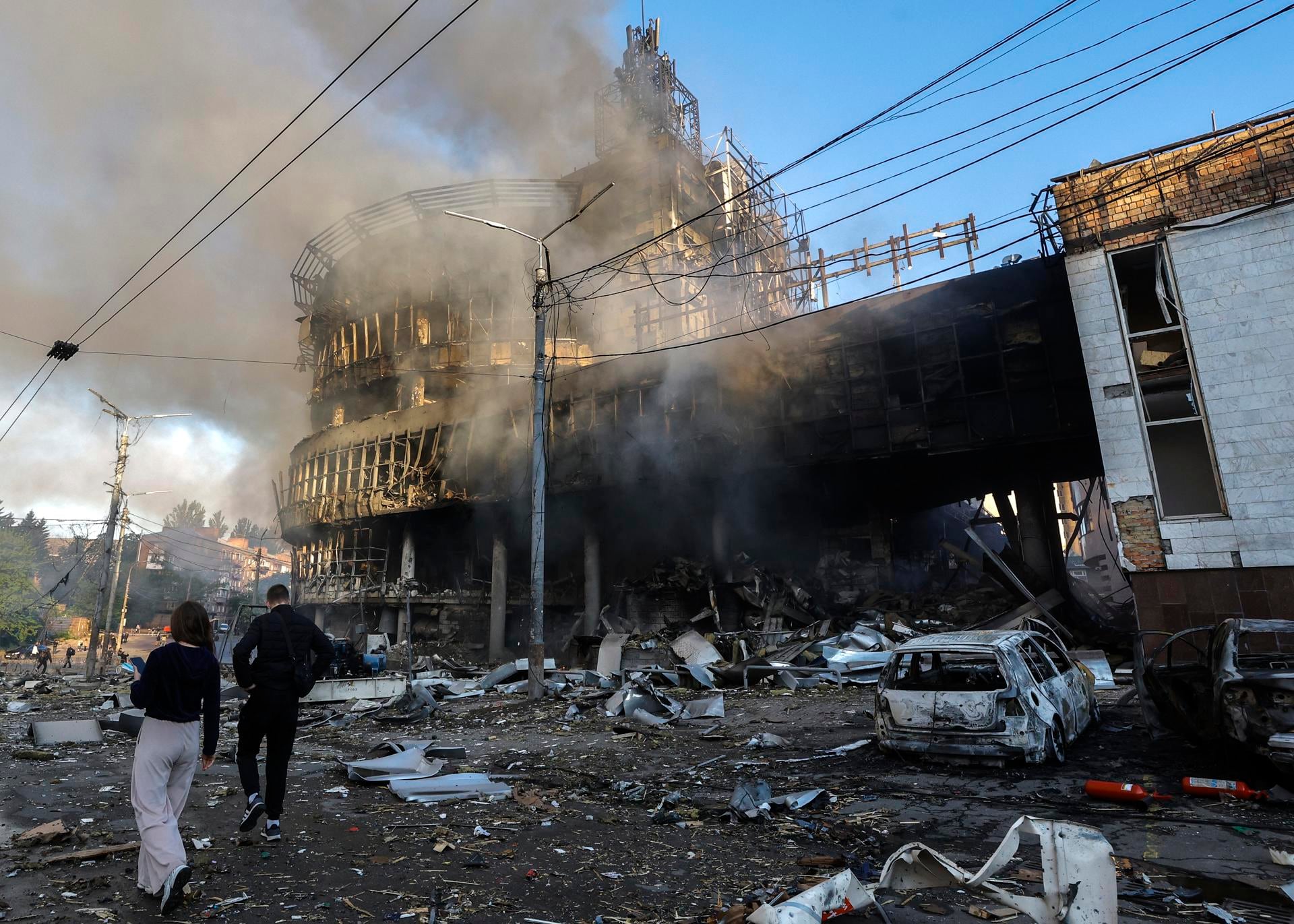 Varias personas caminan entre los escombros en el lugar donde un ataque ruso ha alcanzado un centro comercial en Kiev, Ucrania, el 24 de mayo de 2026. (EFE/SERGEY DOLZHENKO).
