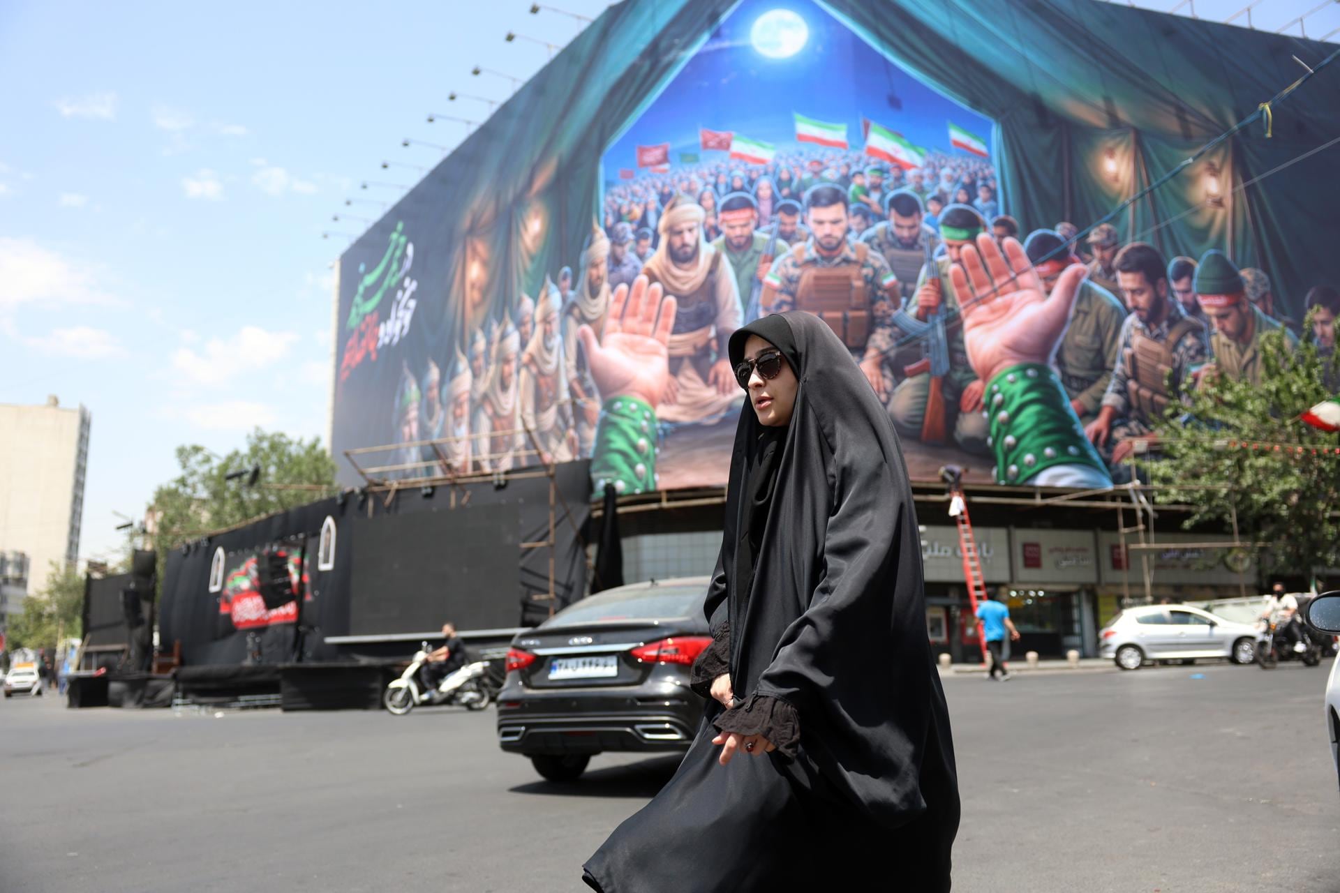 Una mujer iraní pasa junto a una valla publicitaria en la plaza Enqelab de Teherán, Irán, el 18 de junio de 2026. (EFE/EPA/ABEDIN TAHERKENAREH).